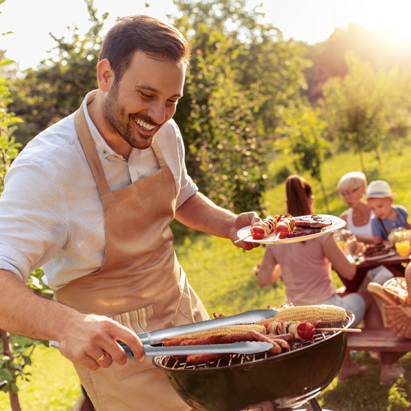 A man using Grillight LED Smart Tongs to barbeque